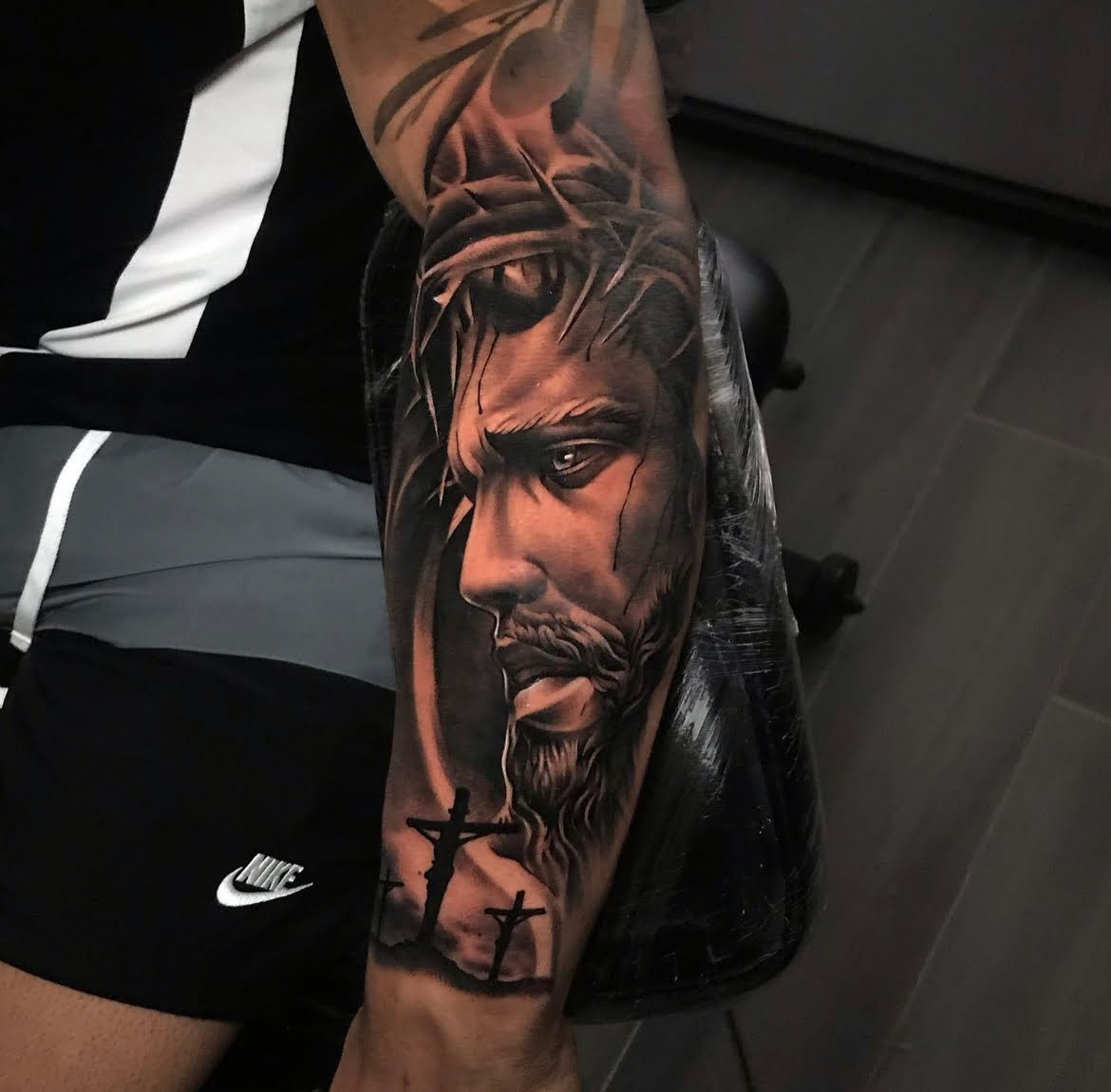 Retrato realista de Cristo con técnica de sombreado en el brazo, transmitiendo contemplación.