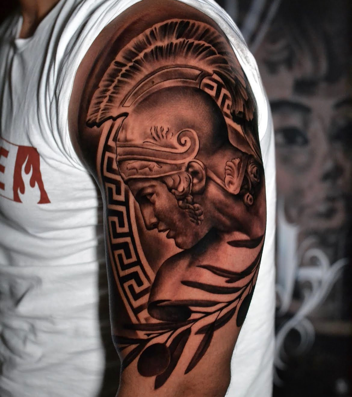 Tatuaje de guerrero griego en estilo blackwork en el brazo, evocando valentía y fortaleza.