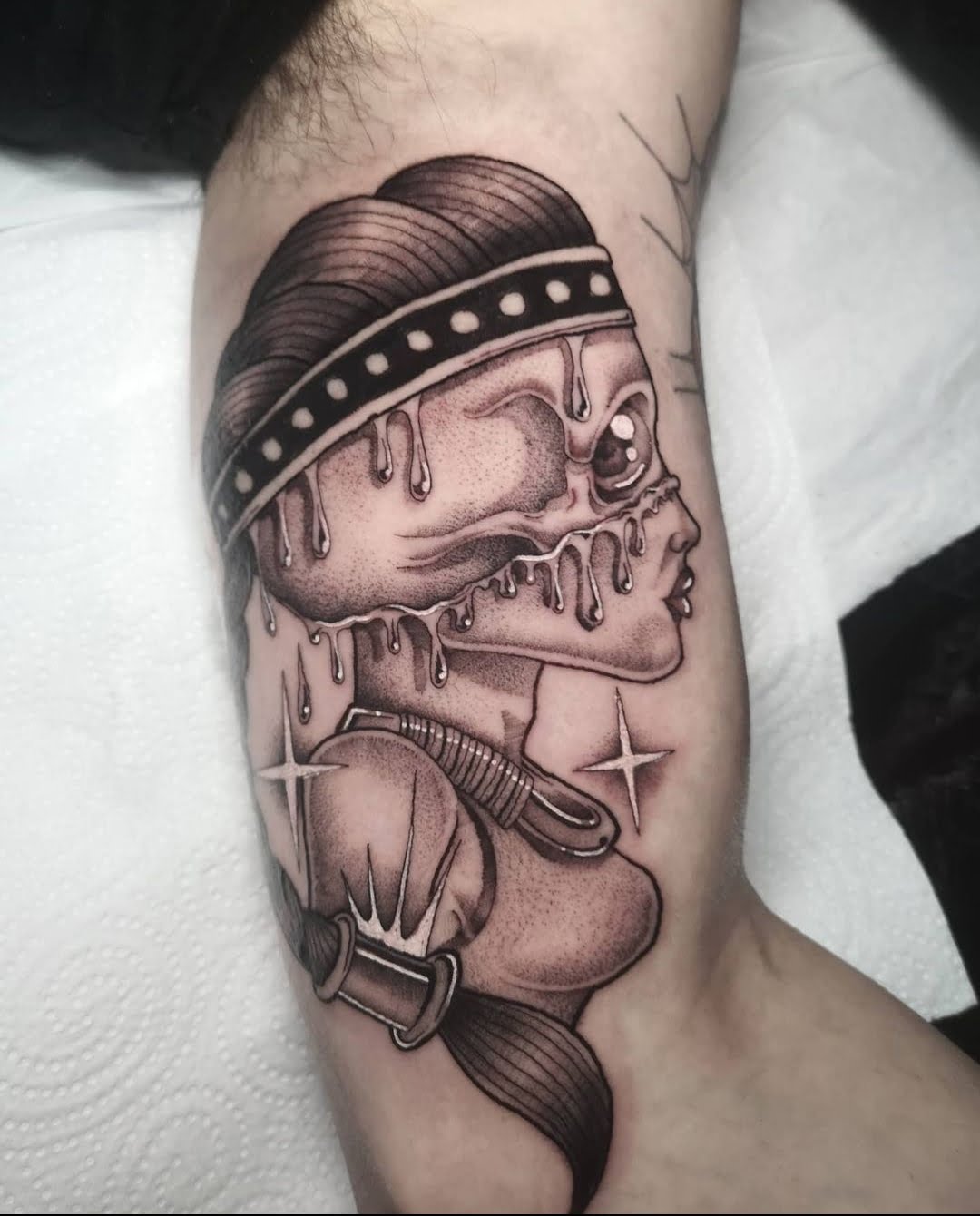 Tatuaje de rostro surrealista derritiéndose en estilo blackwork en el brazo