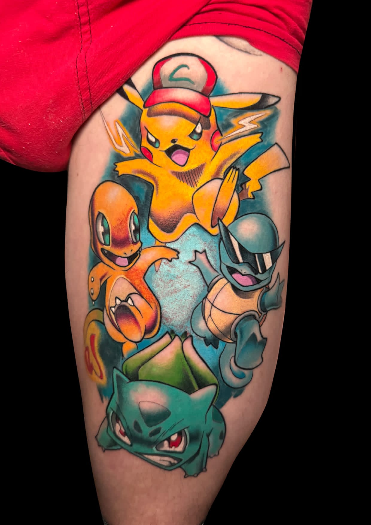 Tatuaje de Pikachu, Charmander, Squirtle y Bulbasaur en estilo neotradicional con colores vibrantes en el muslo.