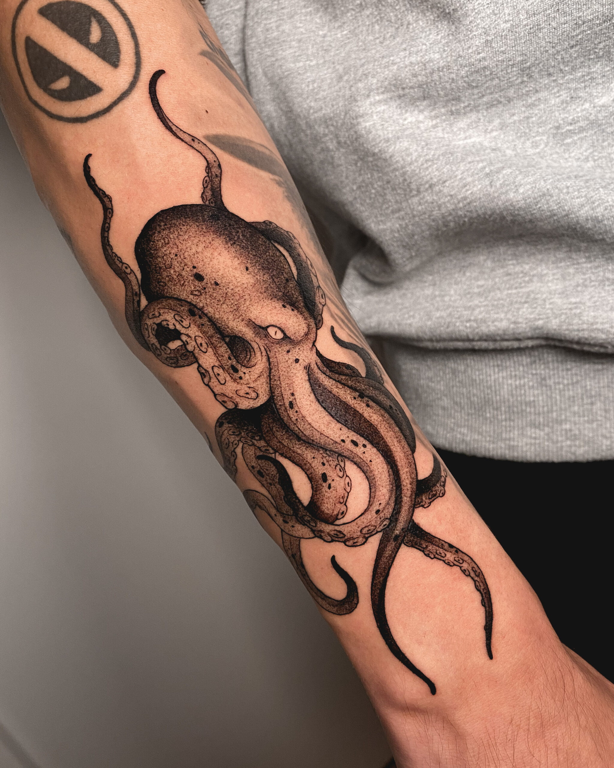 Tatuaje de un pulpo en estilo blackwork con detalles sombreados en el antebrazo.
