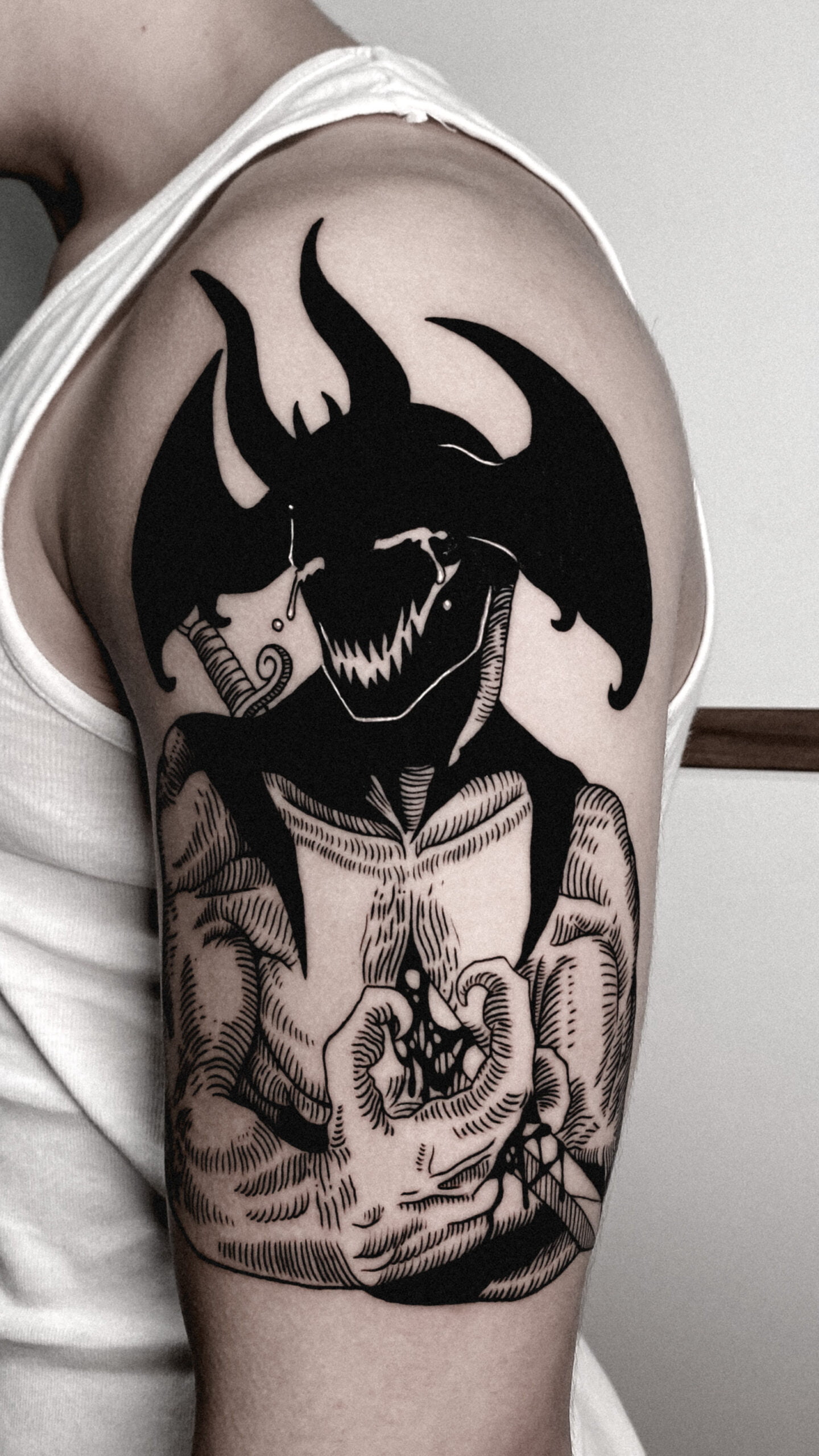 Tatuaje estilo blackwork de un personaje demoníaco en el brazo.