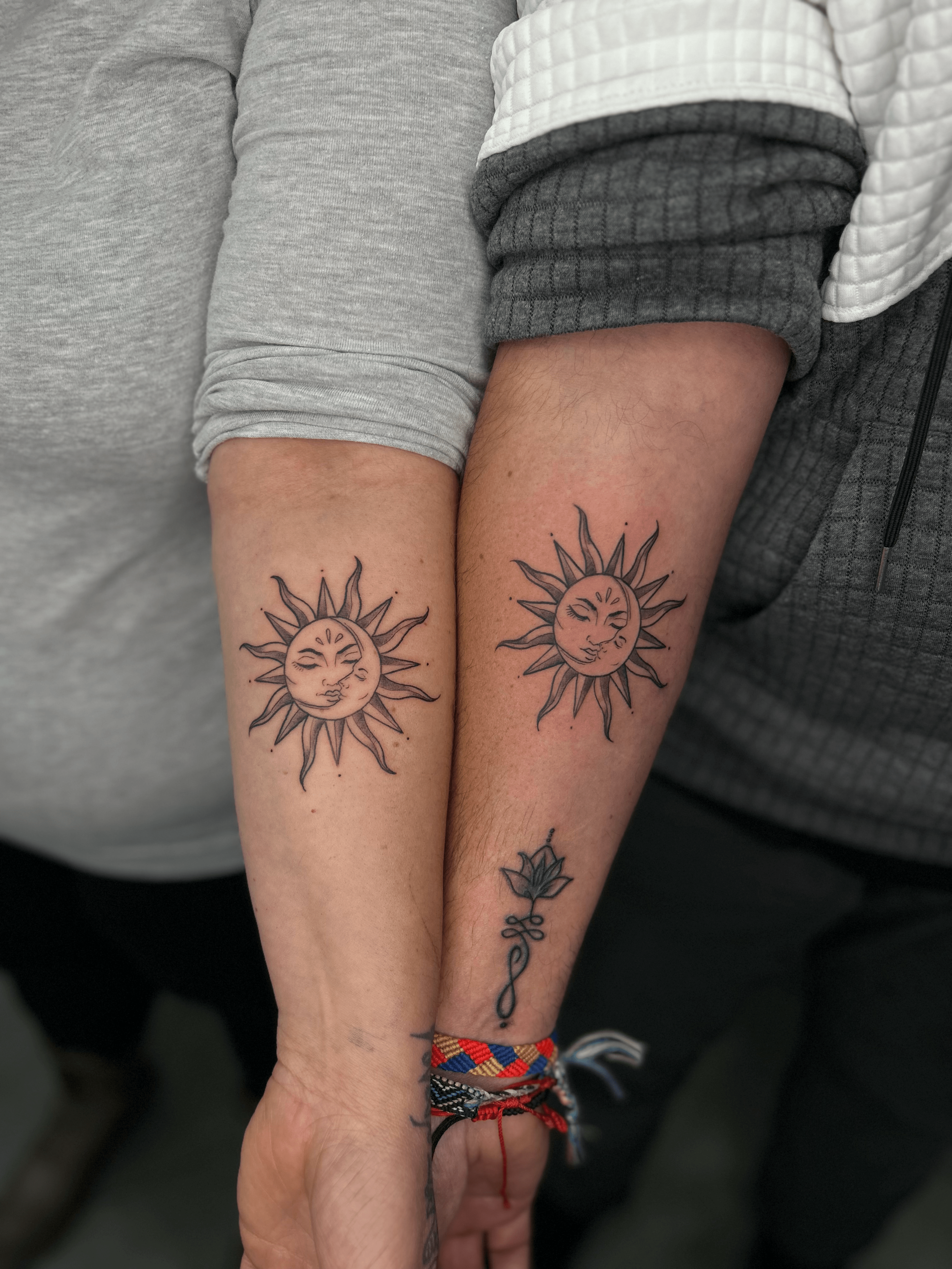 Tatuaje de sol en estilo blackwork en el antebrazo, simbolizando unión y reflejando energía positiva.