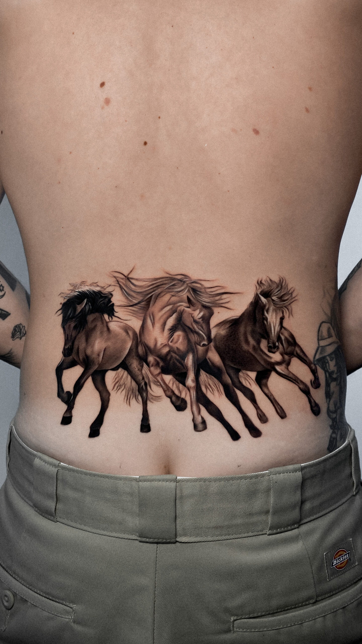 Tatuaje de tres caballos realistas en la espalda con técnica sombreada en black and grey.