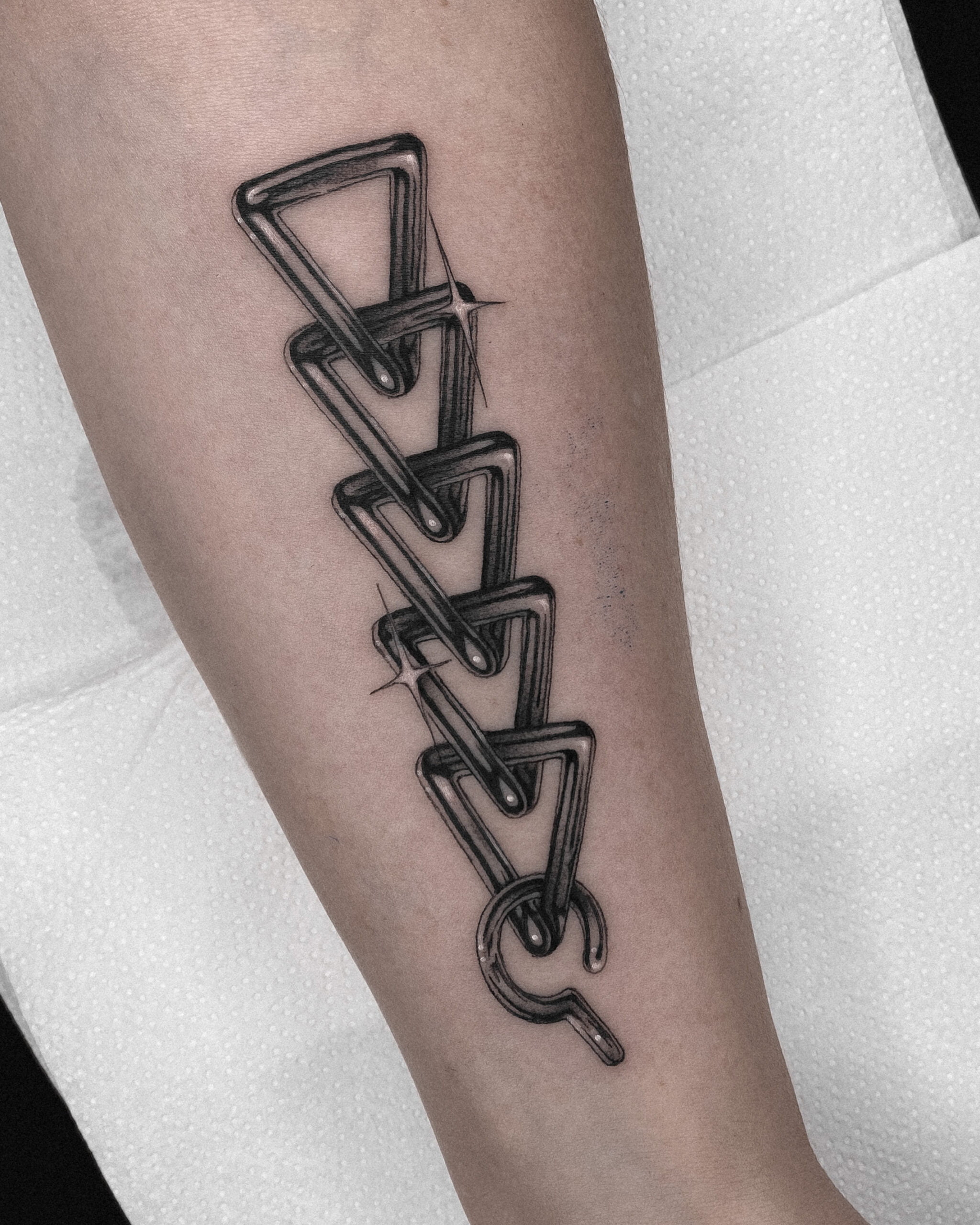 Tatuaje blackwork cadena en el antebrazo