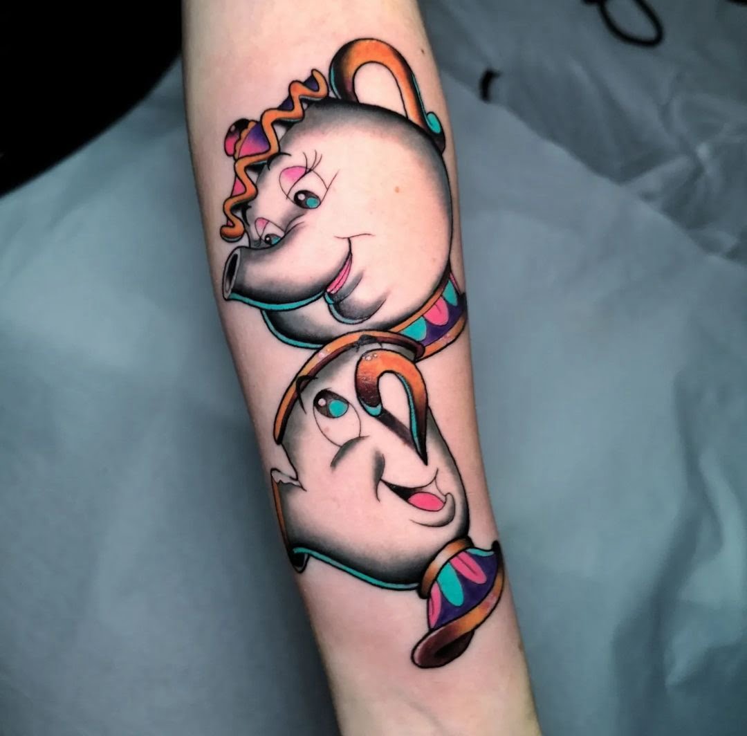 Tatuaje de teteras animadas en estilo neotradicional, con colores vivos en el antebrazo, transmite alegría y nostalgia.