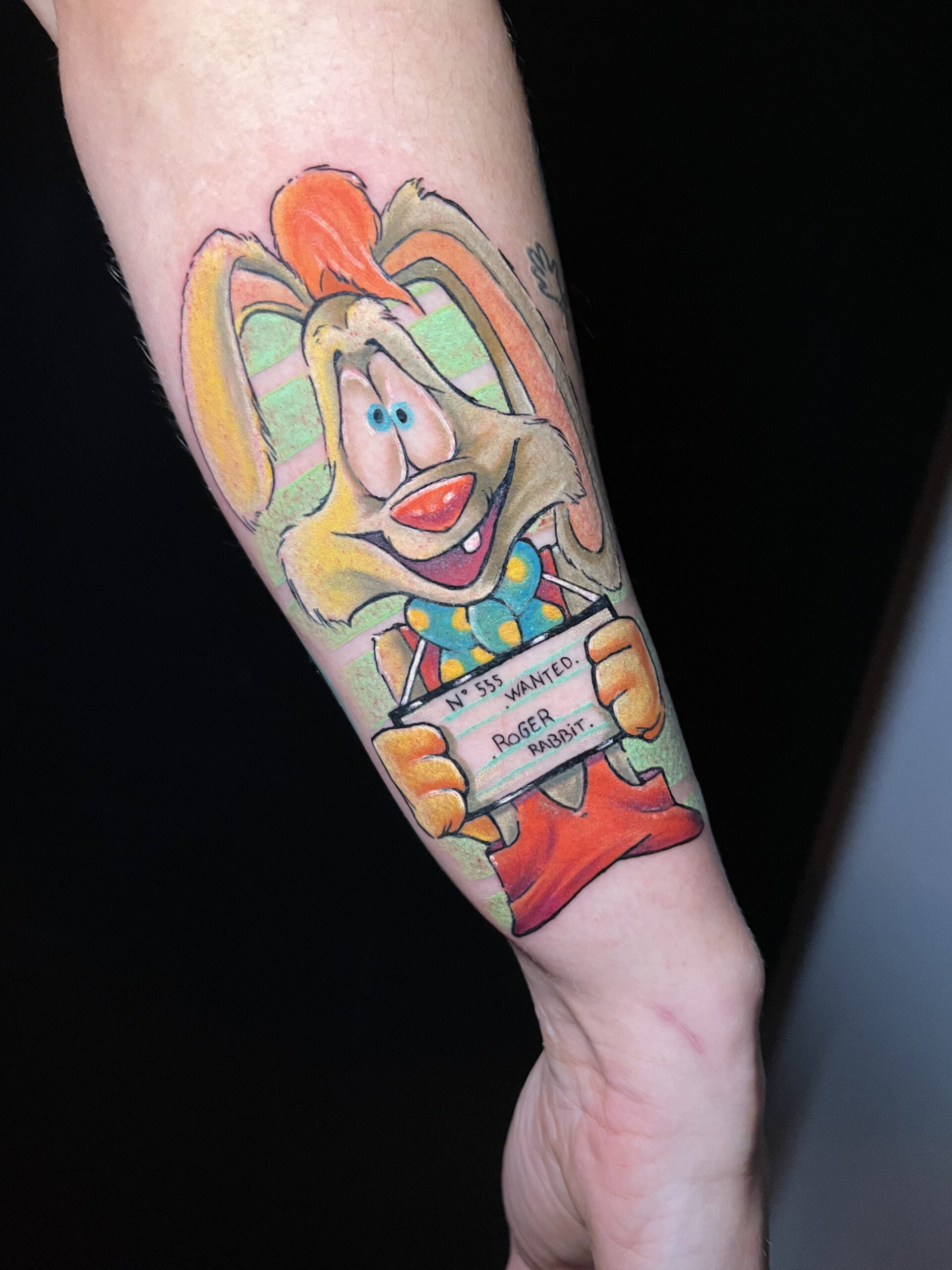Tatuaje colorido de Roger Rabbit estilo neotradicional en el antebrazo, transmitiendo diversión.