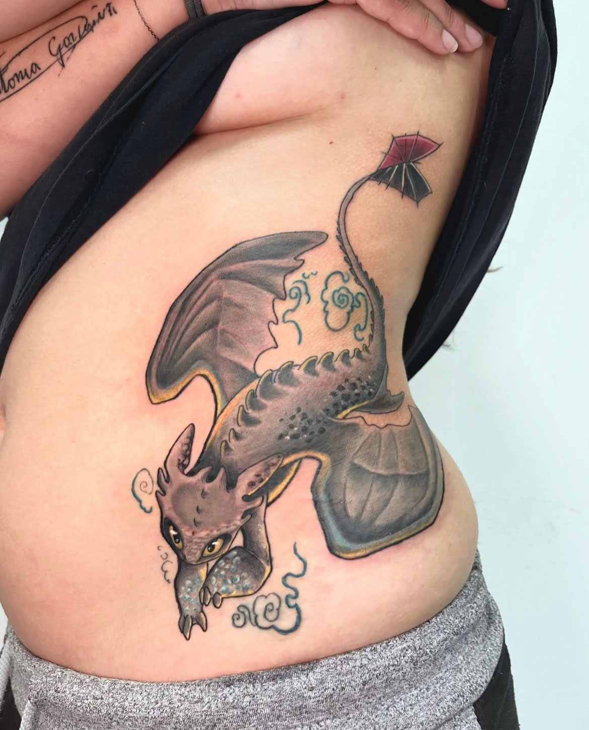 Dragón en tatuaje neotradicional con colores vibrantes en el costado