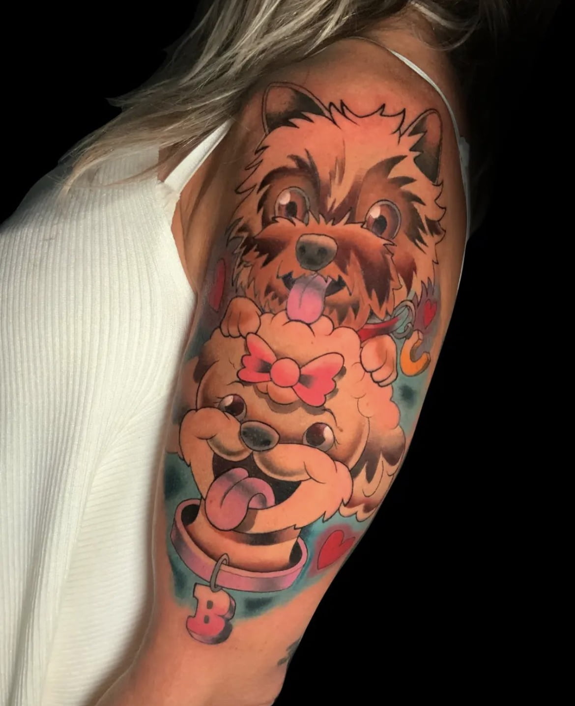 Tatuaje colorido de perros en estilo neotradicional en el brazo, transmitiendo alegría