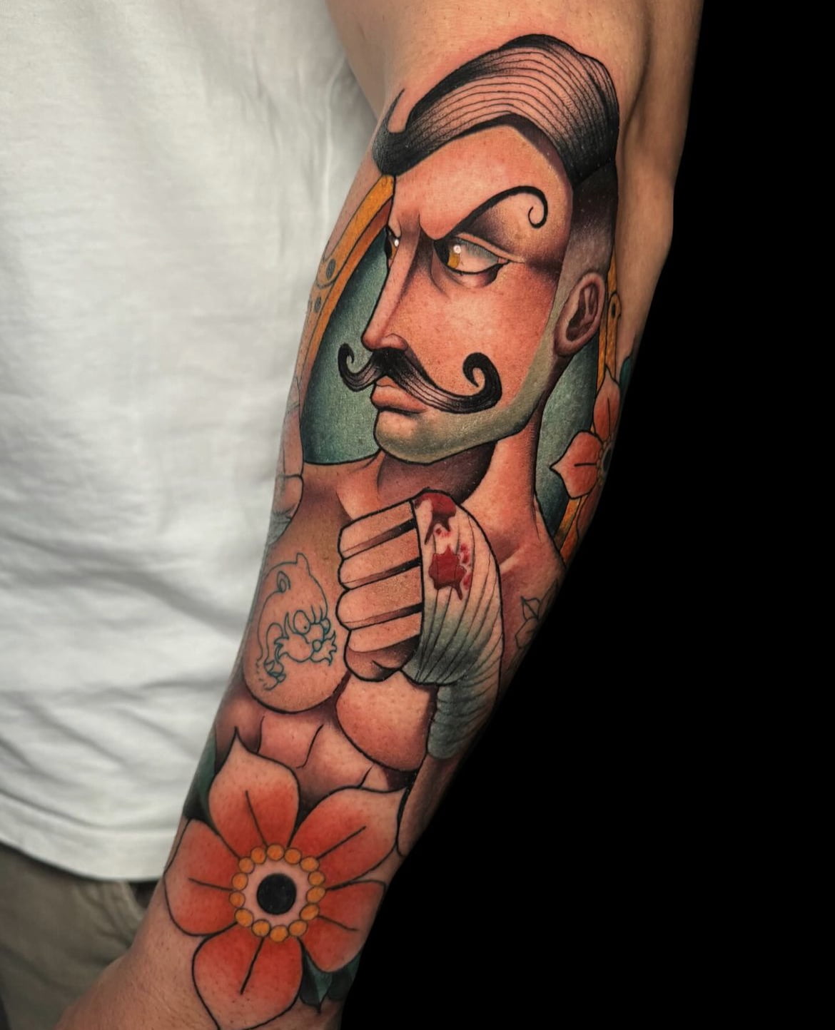 Tatuaje de un boxeador estilo neotradicional en el brazo con colores vibrantes y detalles florales.
