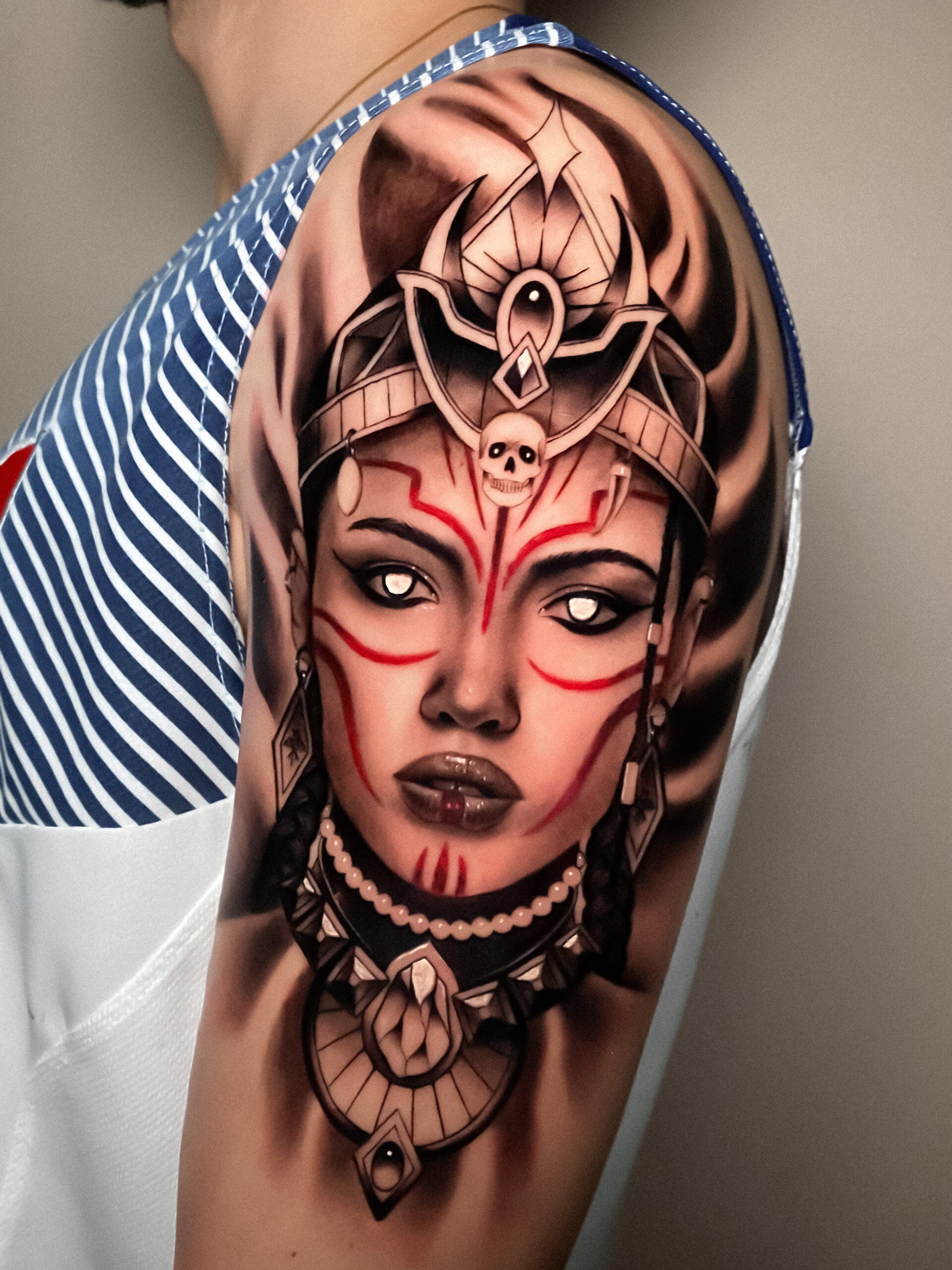 Retrato realista de mujer guerrera con casco y joyas en estilo black and grey en el brazo.