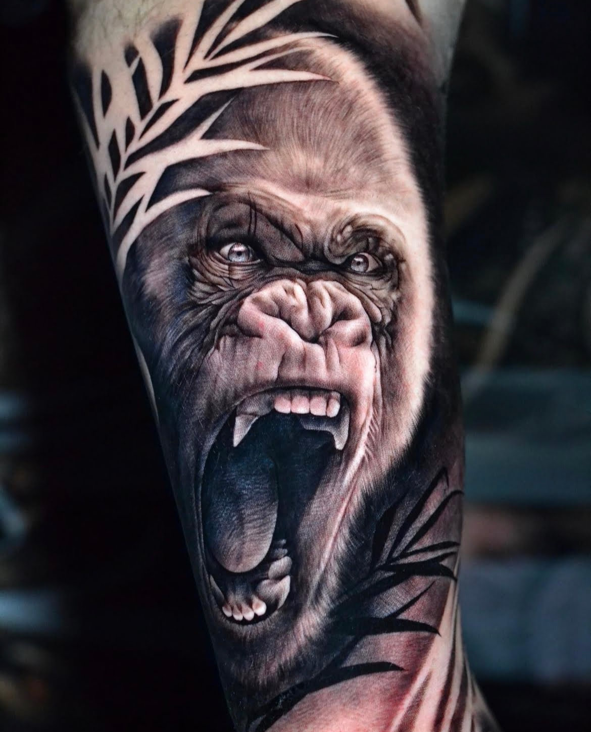 Tatuaje de gorila realista en brazo, estilo black and grey, energía intensa.